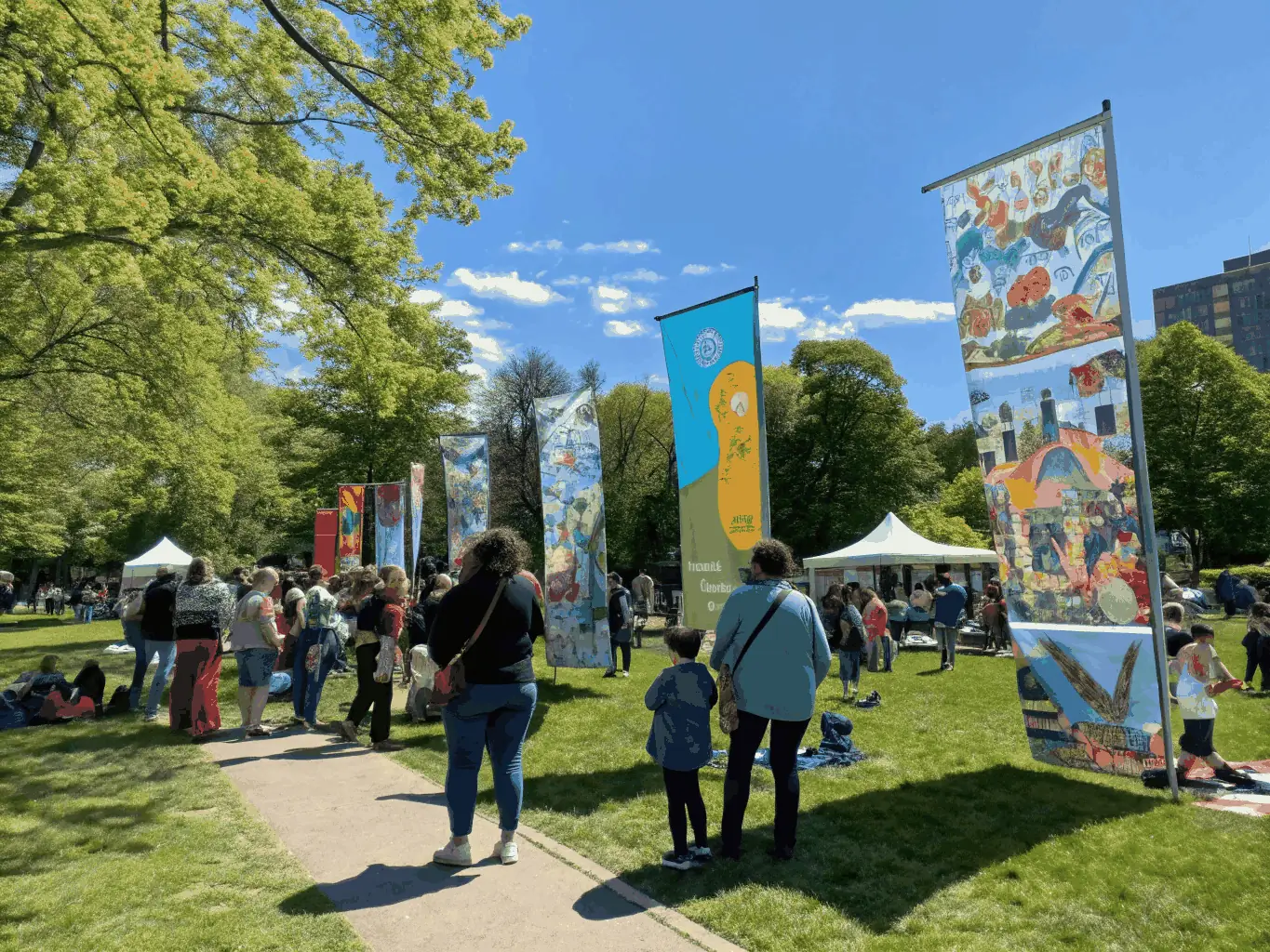 A vibrant image of a community event held in the gardens of a historic estate, showcasing local artisans, musicians, and food vendors.